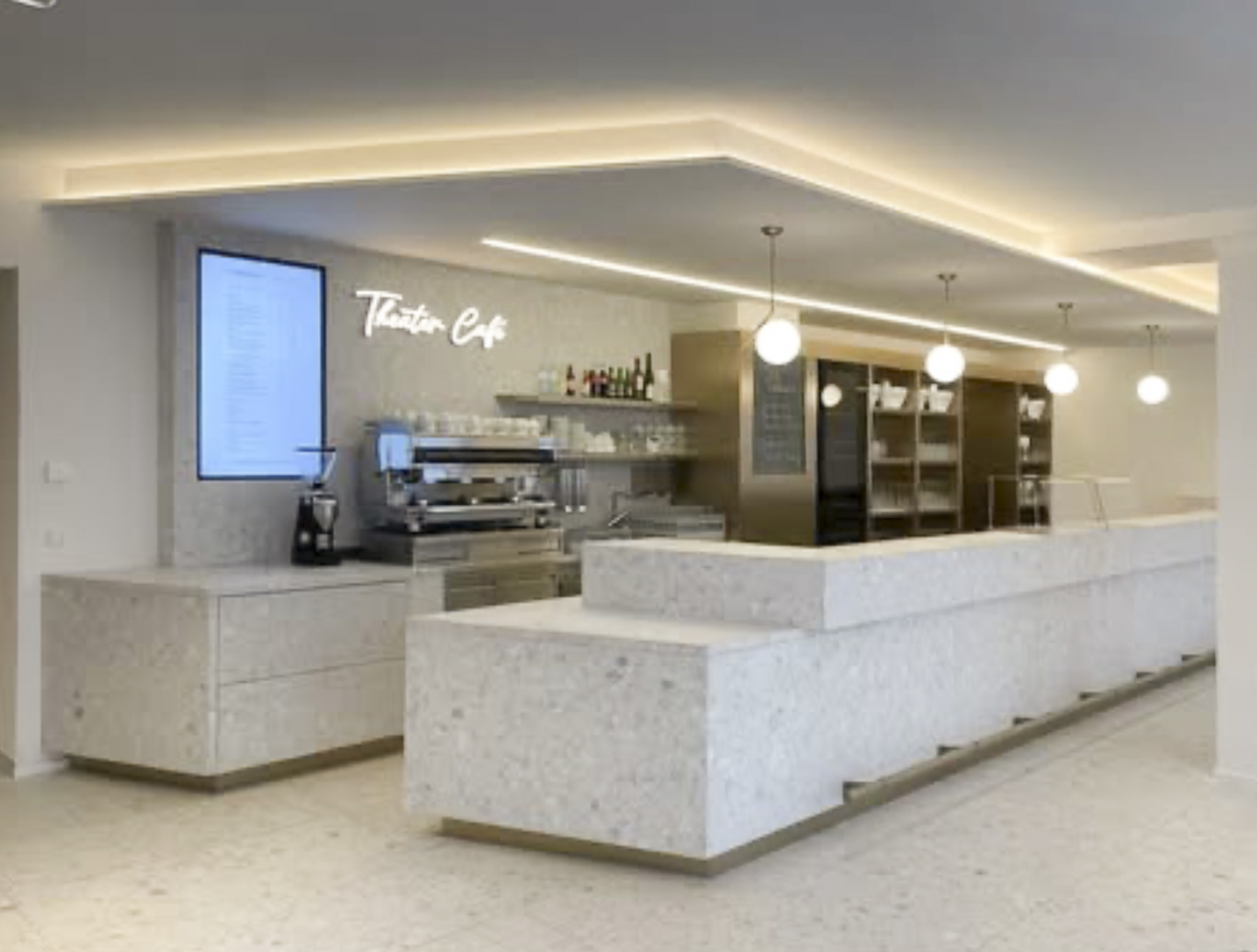 Moderne Theke im Theater Café mit Getränken und Kaffeemaschine.